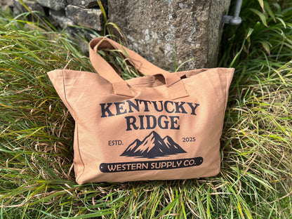 Beige tote bag with 'Kentucky Ridge' branding on grass